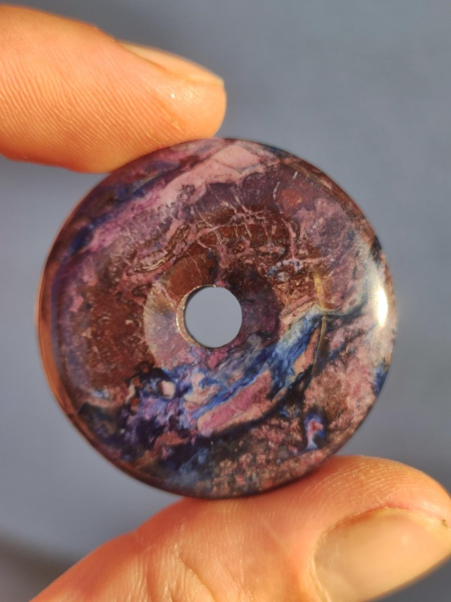 Sugilith & Richterit Bustamit Schutz Donut Edelstein Kristall Heilstein Rarität Selten Sammler Sugilit rot blau lila Anhänger rund Geschenk - Art of Nature Berlin
